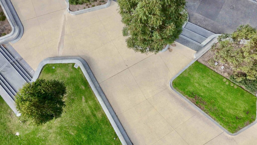 An aerial view of Uni Square's geometric design, showing the contrast between green lawns and the light-toned stone pathways with curved edging from Eigen Stones.