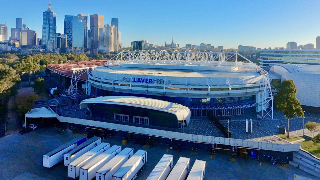 An aerial view of Rod Laver Arena with the Melbourne city skyline in the background, highlighting the extensive public plazas paved with stone from Eigen Stones.