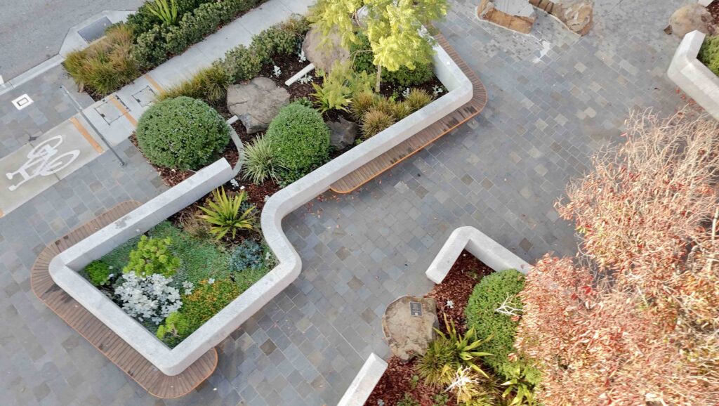 A wide view of the Glencoe Memorial Wall under a blue sky, showing the contrasting polished and textured stone elements supplied by Eigen Stones.