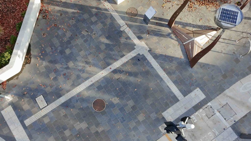 A perspective shot of the Glencoe Memorial Wall, highlighting the polished dark stone pillar against the textured light stone wall, with materials from Eigen Stones.