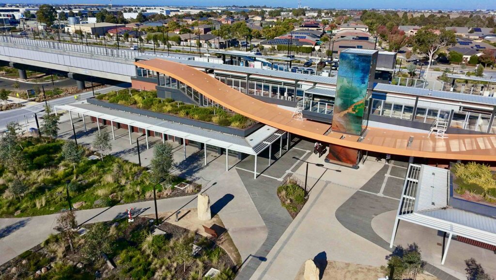 An aerial view of Deer Park Station, showing how the flowing stone pathways and plazas supplied by Eigen Stones integrate the modern building with the surrounding native landscape.