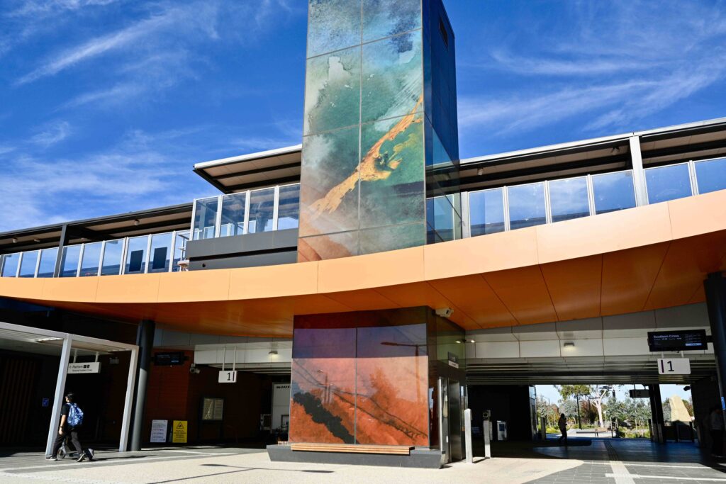 The striking, art-panelled lift tower at Deer Park Station, rising from a clean, modern forecourt paved with stone supplied by Eigen Stones.