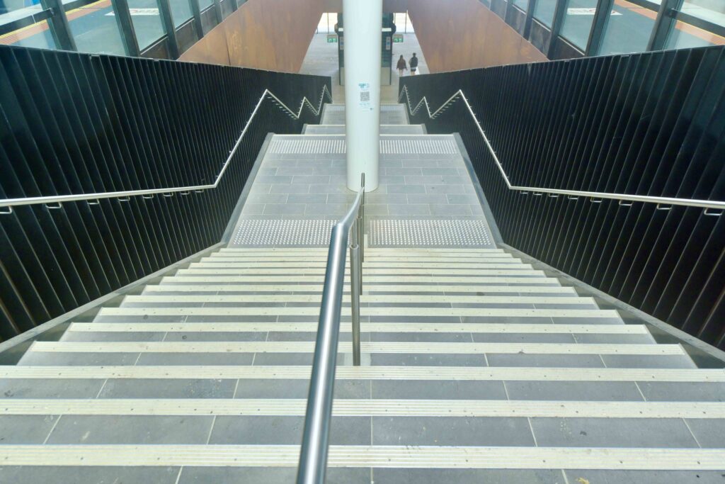 Looking down the main stone staircase at Mernda Station, showing the clean lines and integrated tactile pavers from Eigen Stones.