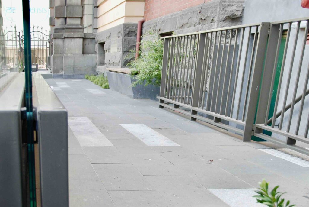 A patterned stone laneway supplied by Eigen Stones runs alongside the heritage brick and stone of the Victorian Women's Centre.