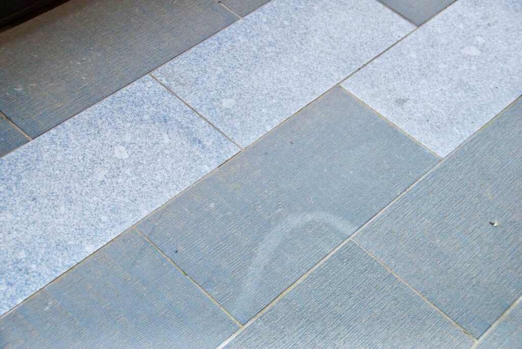 A detailed close-up of the two different stone paver finishes—one textured and one smooth—used in the patterned design at the Victorian Women's Centre, supplied by Eigen Stones.