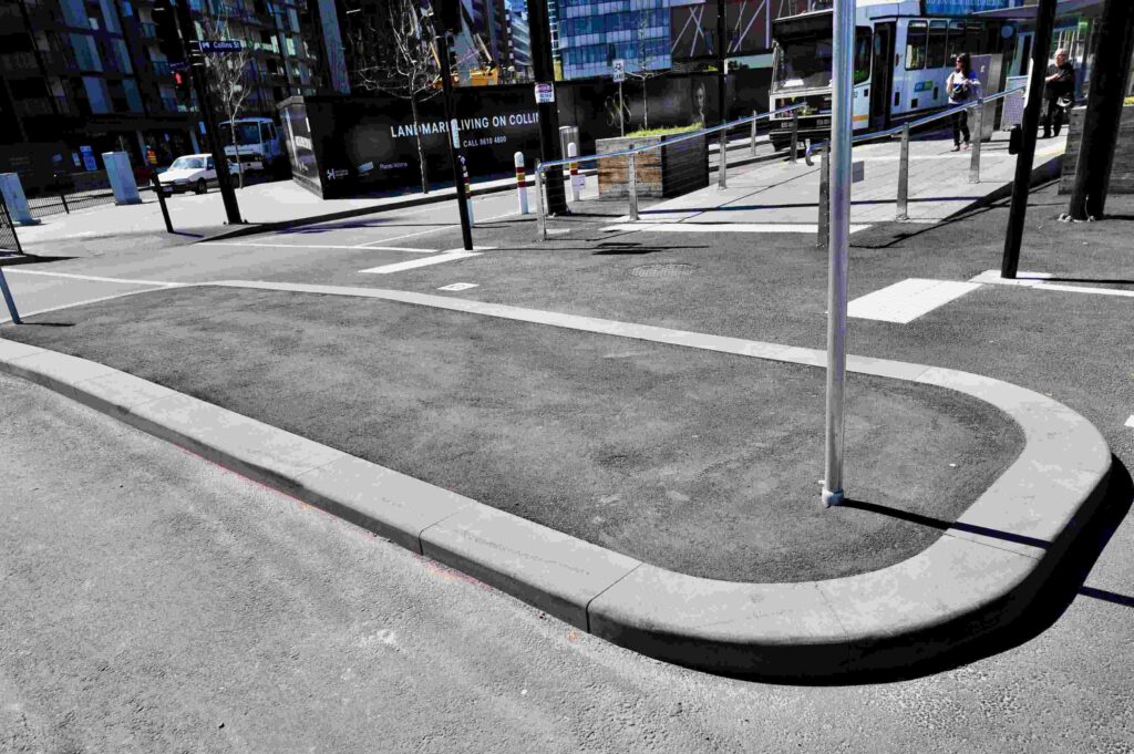 A precisely curved stone kerb, supplied by Eigen Stones, forming the edge of a traffic island in the Docklands precinct.