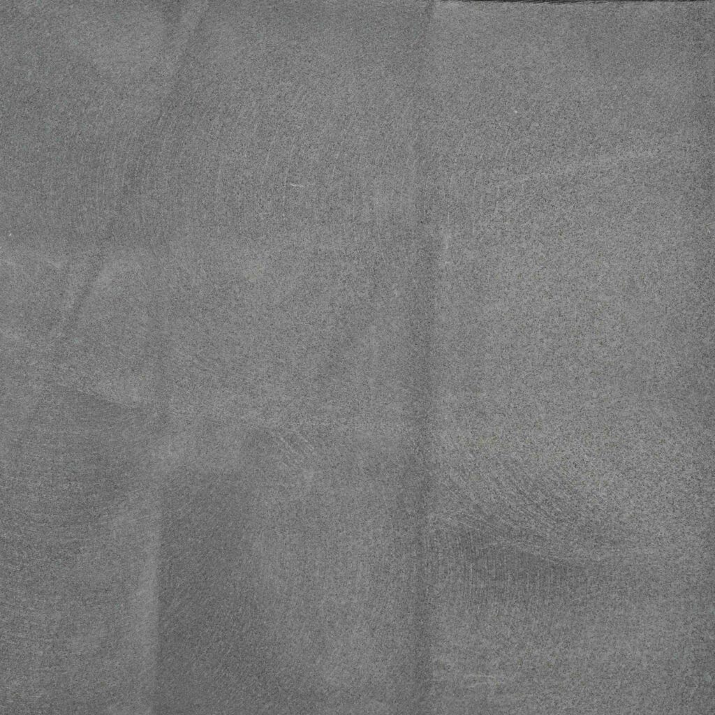 Takhi_Sawn.jpg: A detailed photograph of the Takhi Black Sawn Cut stone paver, showcasing its smooth, matte grey surface with subtle, linear saw marks.